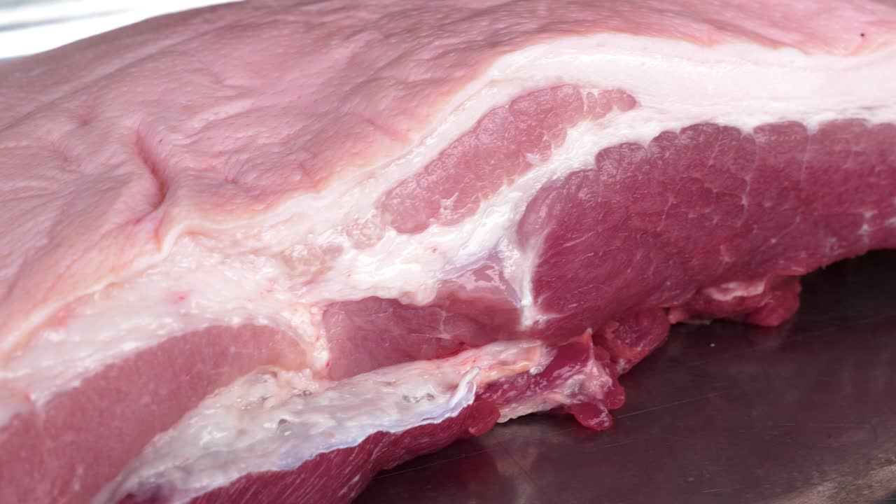 Rohes, majestätisches Schweinebauchfleisch in Nahaufnahme und Bewegung