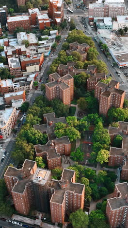triangle neighborhood with unusually shaped brick buildings among the greenery. new york scenery from top. vertical video