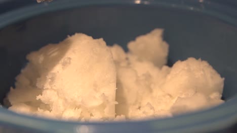 Shea butter being added for cannabis salve oil preparation, close up