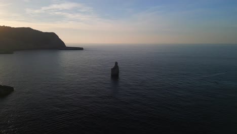 small island in bay, silhouette at sunset