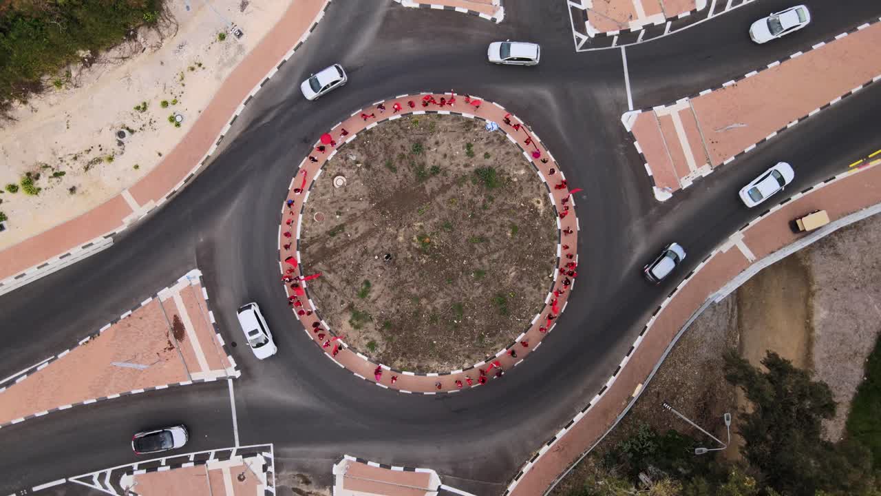 Aerial descending shot above a women's day demonstration on a roundabout in Israel