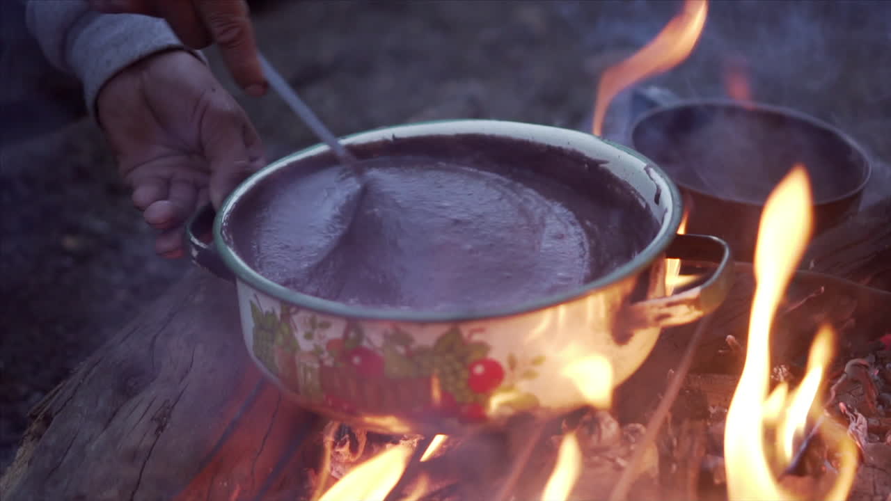 Slow motion of a spoon stirring bean stew as preparations for dinner are underway.