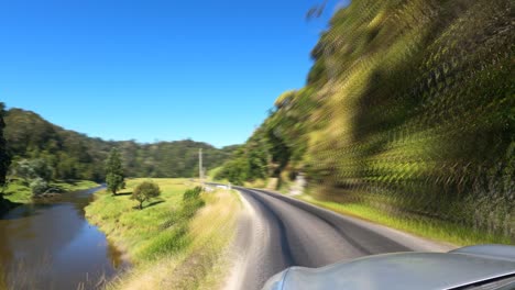 car's pov driving in the road going to mount damper falls with green landscapes in new zealand