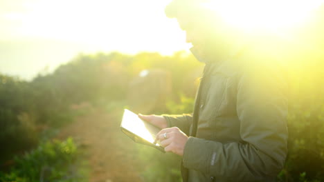 Un-Joven-Usando-Una-Tableta-Al-Aire-Libre