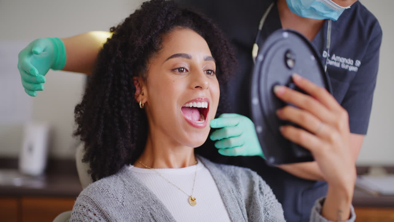 Dentist showing female patient mirror to check