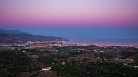 Vista-Aérea-De-La-Puesta-De-Sol-Con-Las-Luces-Encendidas-En-La-Ciudad-De-Torre-Del-Mar-En-España