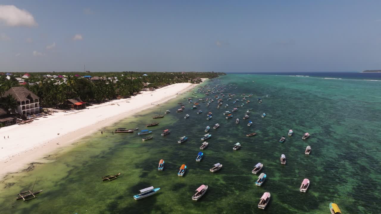 Matemwe beach, Wide aerial overview Zanzibar white sand shoreline with boats scattered over clear reef-filled tropical ocean