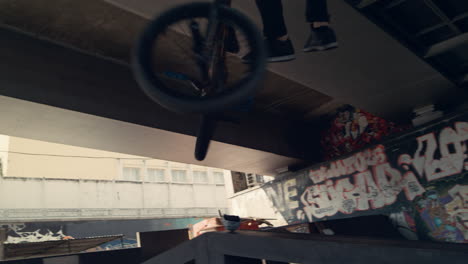 밀레니얼 바이커  ⁇ 스터가 자전거 bmx와 함께 램프에서 활동적인 레저를 위해 경주하고 있습니다.