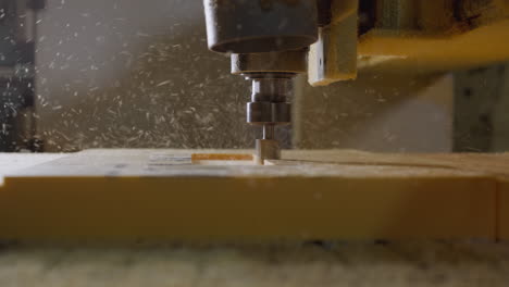 cnc tool cutting foam, close-up with dynamic particle spray in a workshop