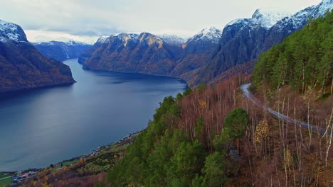 Dangerous-mountain-side-road-and-majestic-lake,-aerial-drone-fly-forward-view