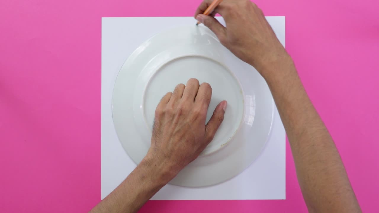 Using porcelain plate to draw circumference on paper, pink background