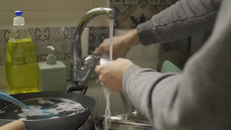 washing kitchen utensils by hand during a sunny day