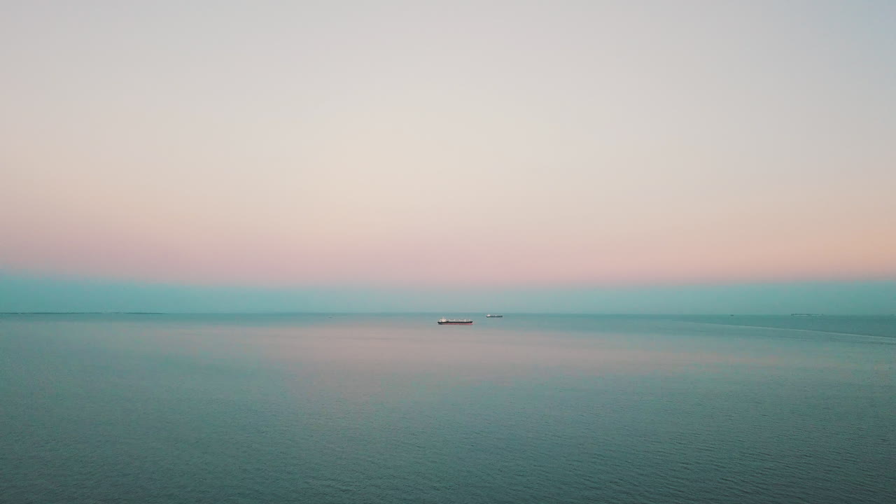 일몰-1에서 화물선을 배경으로 바다 위를 날고 있는 드론