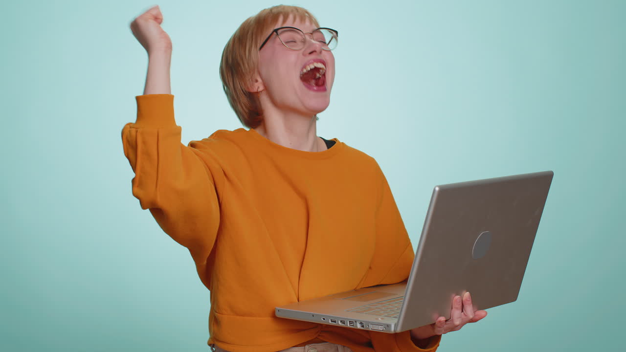 Donna che lavora su un progetto di portatile che si gode dei risultati che vince la lotteria che celebra il successo del vincitore