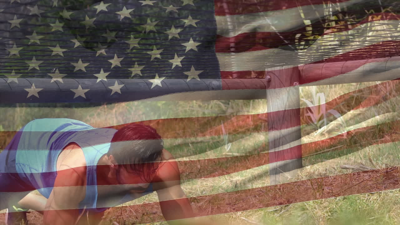 atleta arrastrándose bajo una pista de obstáculos