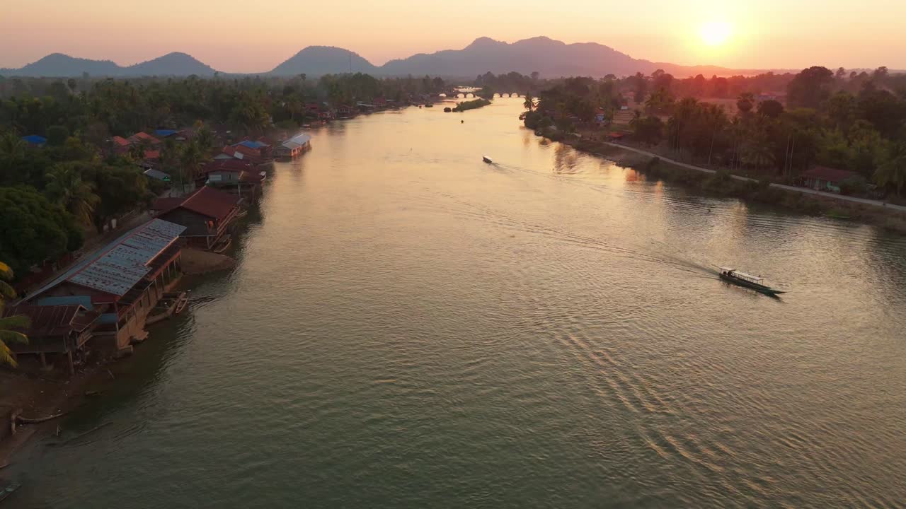 Aerial drone fly sunset reflected at Four Thousand Islands, boats sail Laotian tropical landscape in Laos