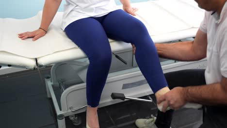 fisioterapeuta masculino evalúa la movilidad de las piernas y las rodillas de la paciente femenina