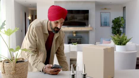 opening package, man scanning barcode with smartphone in modern kitchen