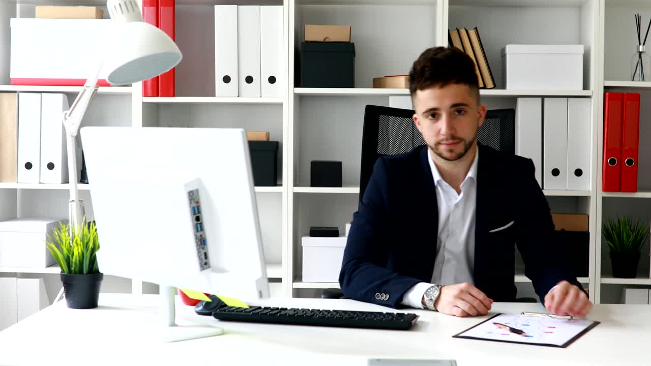 giovane uomo d'affari nello spazio di lavoro che guarda la telecamera