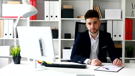 giovane uomo d'affari nello spazio di lavoro che guarda la telecamera