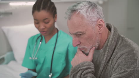 un paciente anciano está preocupado por los resultados médicos que le lee una joven doctora estadounidense