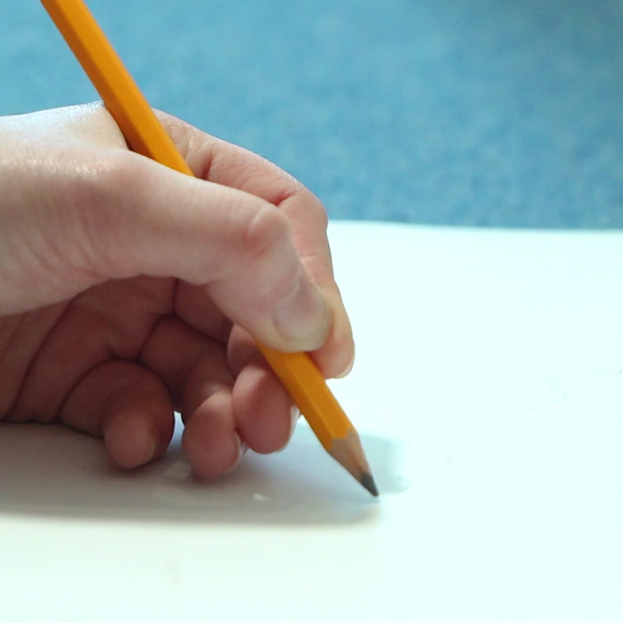 Female hand drawing with a pencil in sketchbook. Young woman learns to draw.