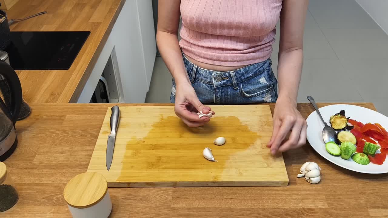 Woman preparing garlic and vegetables in the kitchen
