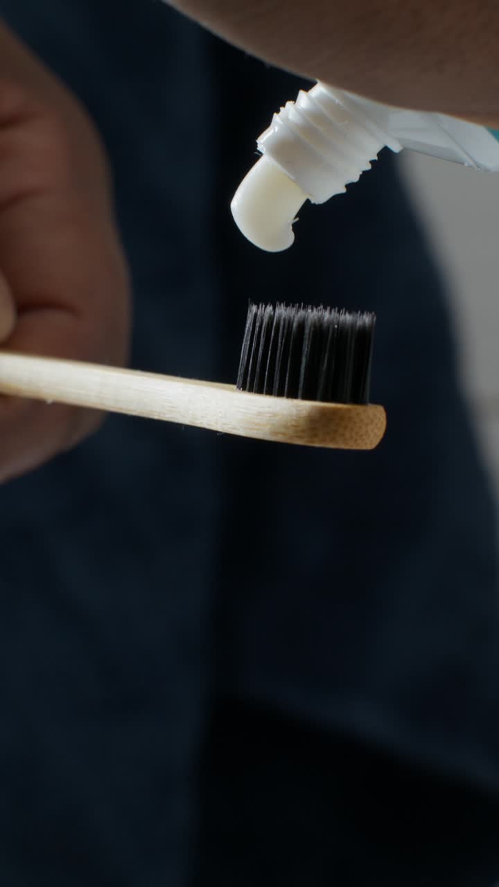 Person holding bamboo toothbrush with toothpaste