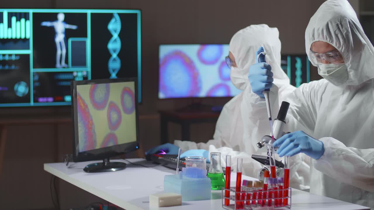 Two Asian Doctors In Protective Suit Are Doing A Science Experiments And Developing Vaccine In A Modern Lab. Laboratory Assistant Workplace. The Concept Of Science And Medicine