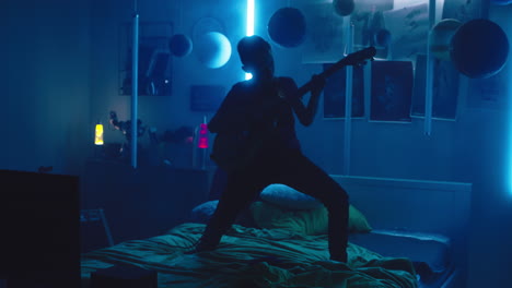 silhouette of a person playing guitar in a dark room