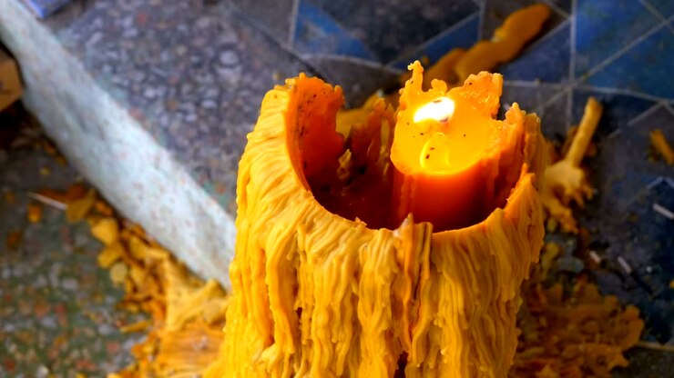 Big candle burns in the Buddhist temple of Eden and Hell. Thailand