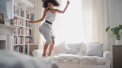 happy woman dancing jumping on sofa having fun celebrating enjoying playful dance celebration successful female lifestyle achievement 4k