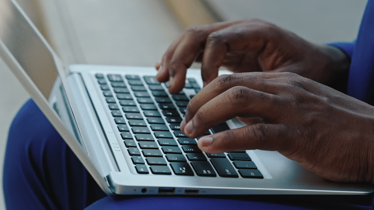 Close-up of hands typing on a laptop keyboard