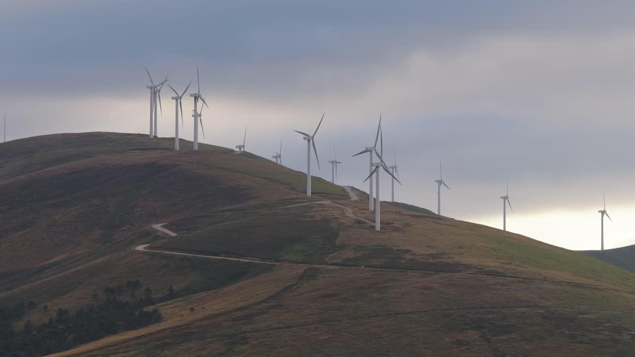Wind turbines rotating on hilltop in cantabria, spain