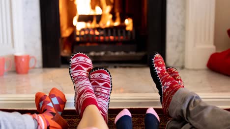 Animation-of-feet-of-african-american-family-in-christmas-socks-resting-in-front-of-fireplace