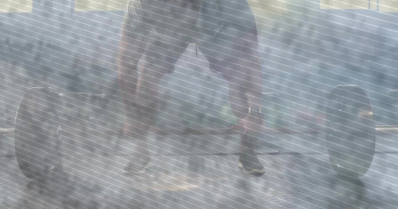 Uomo in maglietta e pantaloncini che assume una posizione ampia, sollevando un bilanciere carico in palestra, durante l'allenamento.