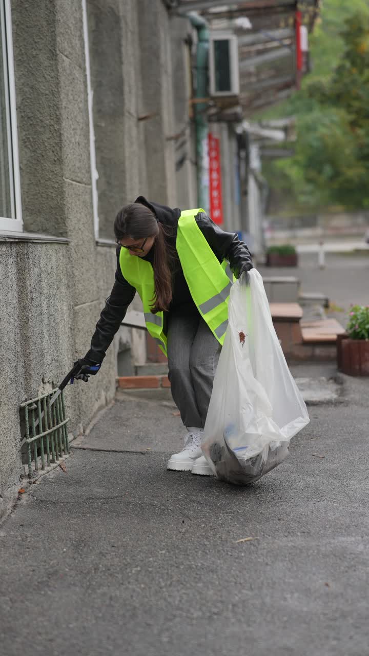 mujer limpiando la basura en la calle
