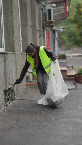 woman cleaning up litter on the street