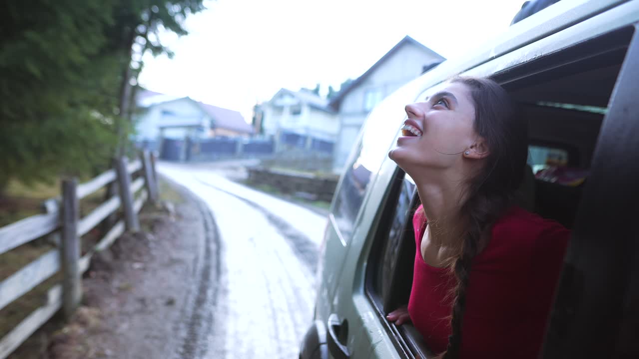 행복 한 여자 가 차 창문 밖 을 바라보고 있다