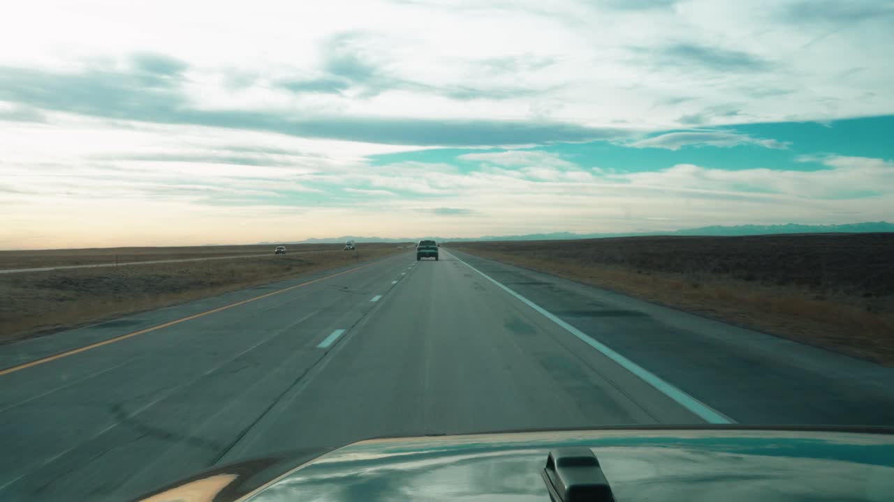 멀리 있는 다른 차량과 함께 평평한 풍경의 열린 고속도로에서 운전하는 자동차의 탁 트인 전망