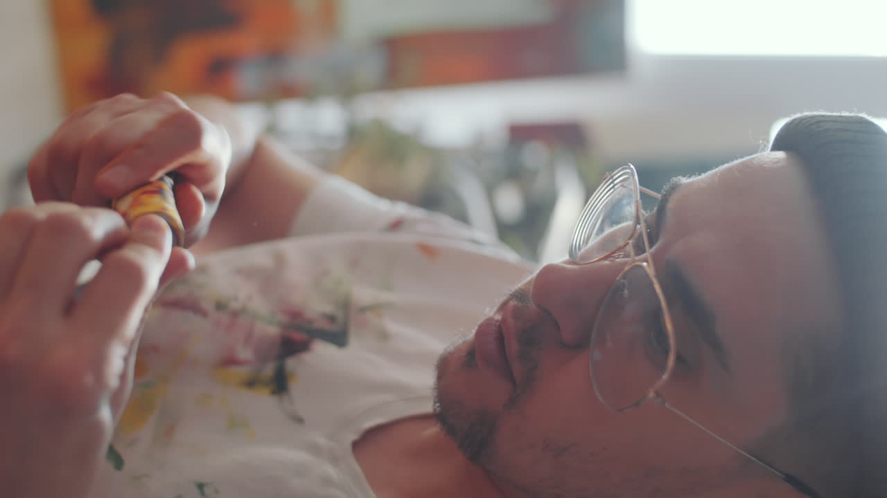 artista masculino mezclando colores de pintura en una paleta de madera