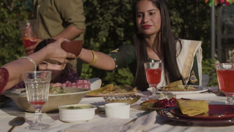 family enjoying an outdoor meal with refreshing drinks in a garden setting