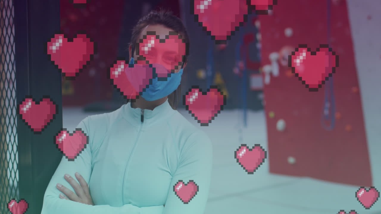 체육관에서 마스크를 착용한 백인 건강한 여성의 초상화에 대해 떠다니는 분홍색 심장 아이콘