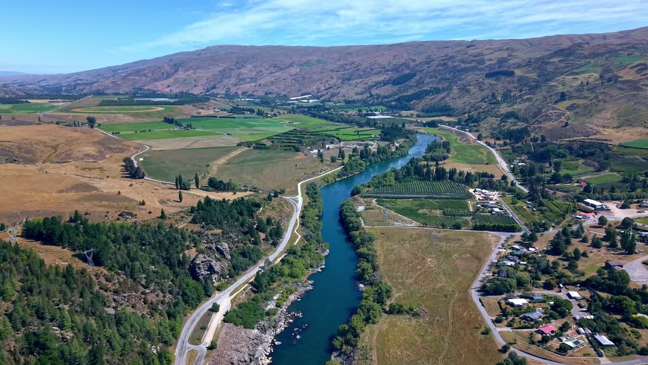 Aerial drone footage captures famous iconic scenic New Zealand landscape following one of New Zealand's most powerful, and longest rivers the clutha downstream on beautiful sunny day
