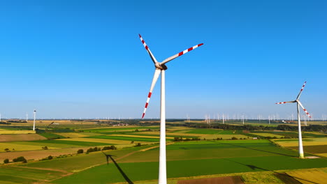 blades of wind turbines with red stripes rotate in the wind. aerial view on the fields with wind farms. green energy concept.