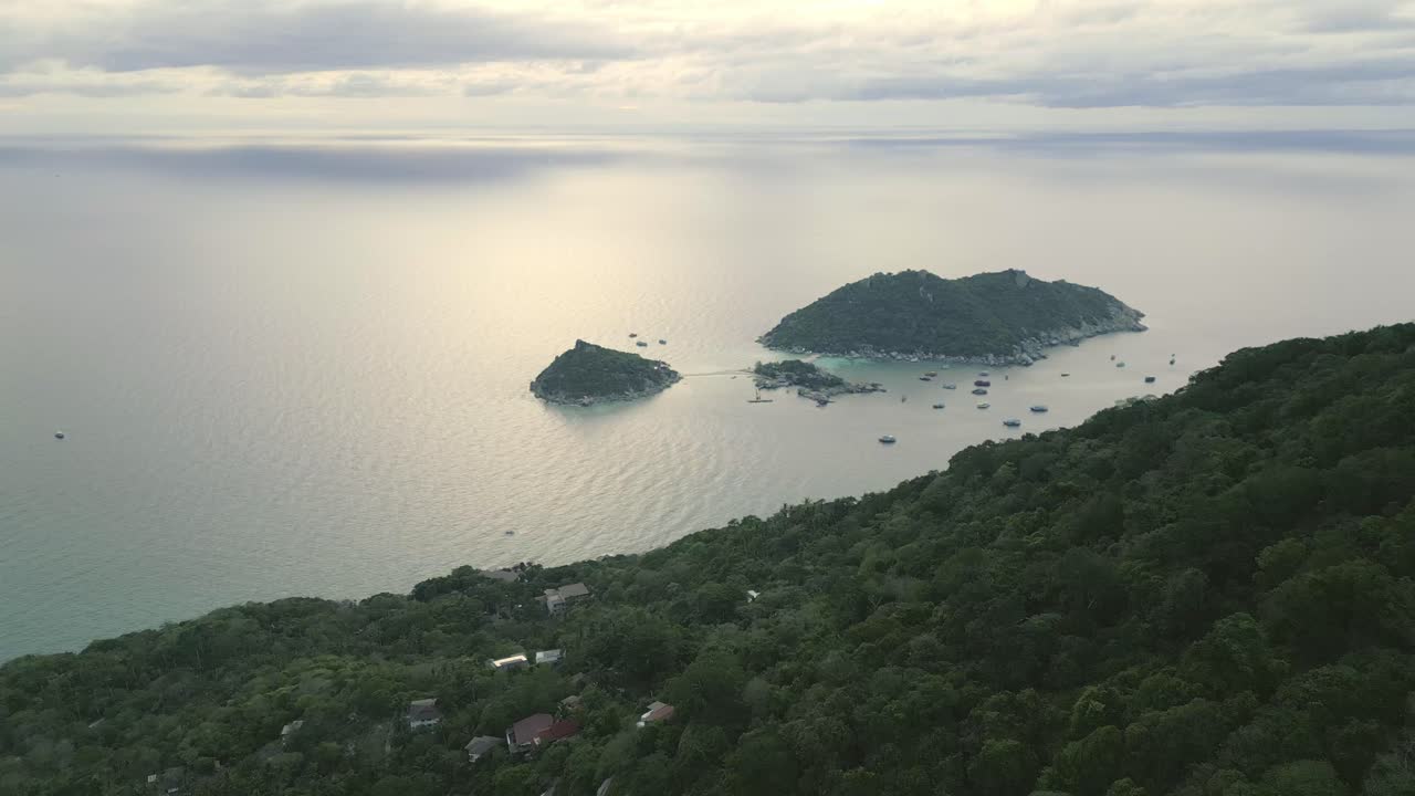 vista aérea de la costa de la isla de nang yuan al atardecer, con aguas turquesas y un entorno verde exuberante que brilla en la luz que se desvanece