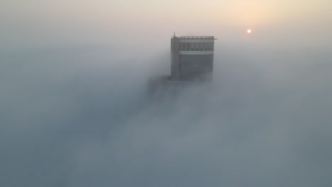 water tower emerging from fog at sunrise