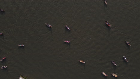 view of small boats sailing and mooring at the side of the port at sadarghat river, dhaka, bangladesh