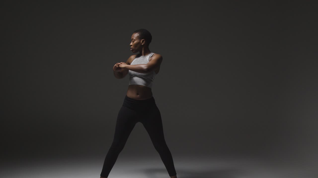 Studio Shot Of Young Woman Wearing Gym Fitness Clothing Warming Up For Exercise 5