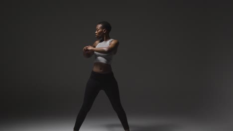 Studio-Shot-Of-Young-Woman-Wearing-Gym-Fitness-Clothing-Warming-Up-For-Exercise-5